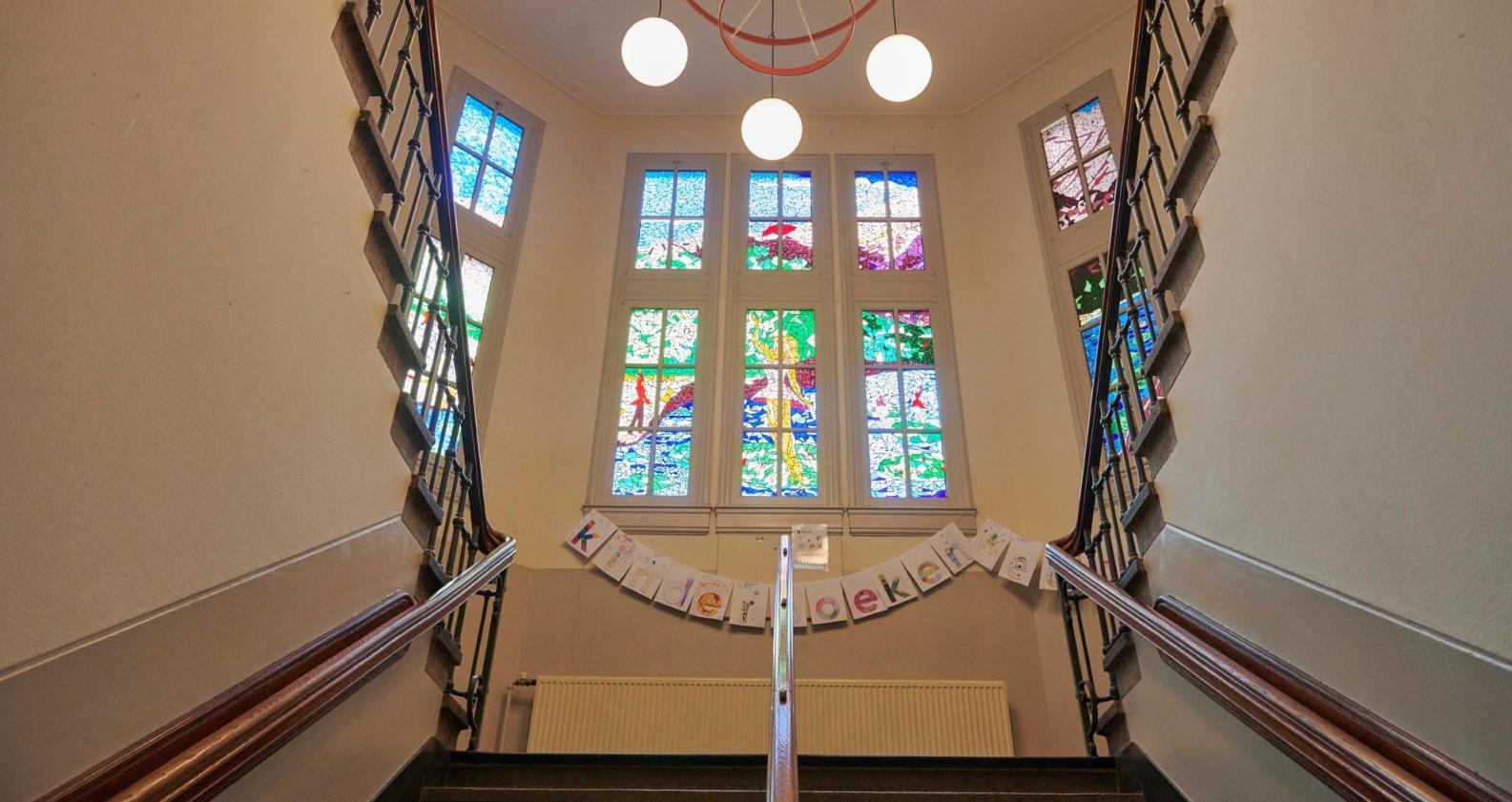Trap met kleurrijke glas-in-loodramen in Openbare Basisschool De Kring te Haarlem. Trap met kleurrijke glas-in-loodramen in Openbare Basisschool De Kring te Haarlem.