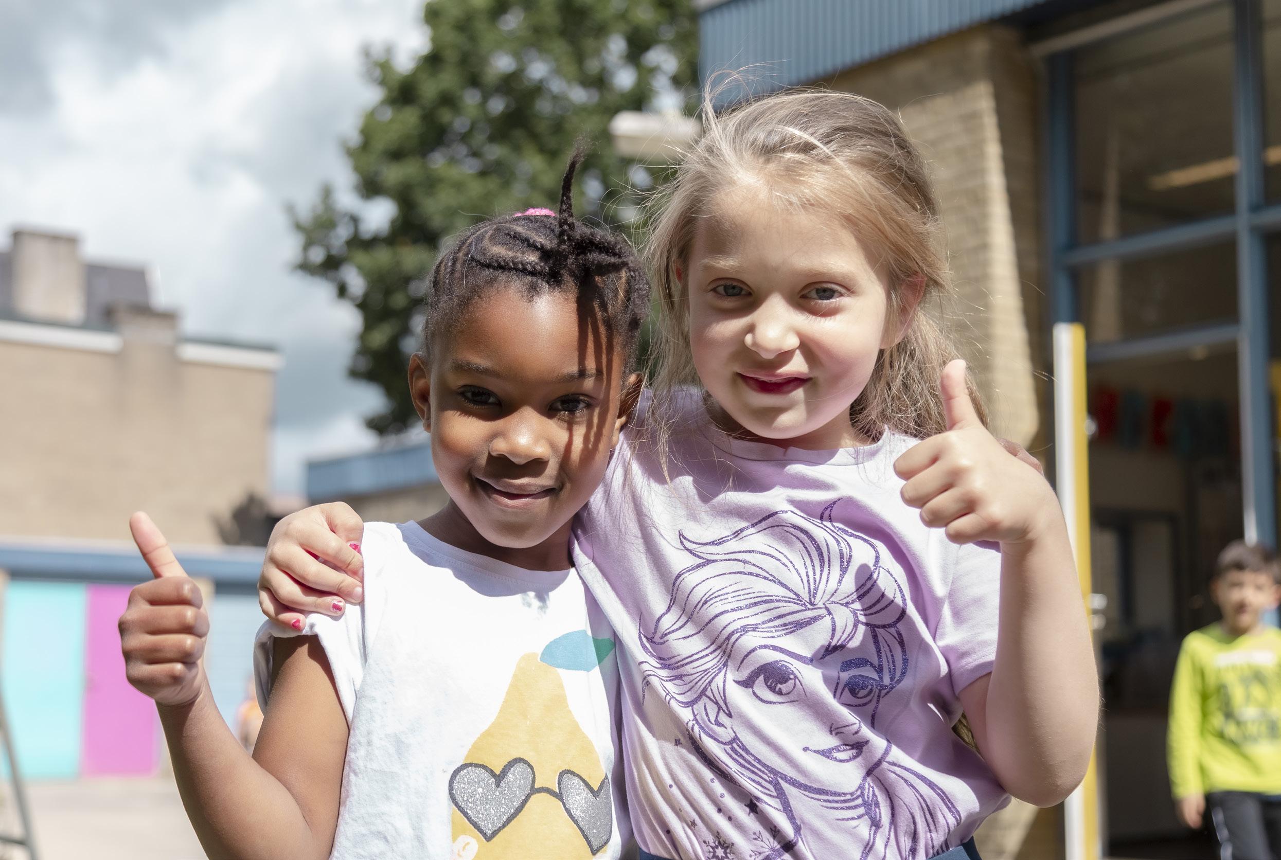 Twee blijdschappige kinderen geven een duim omhoog op het schoolplein van Beatrixschool, locatie Zuilenstein in Nieuwegein. Twee blijdschappige kinderen geven een duim omhoog op het schoolplein van Beatrixschool, locatie Zuilenstein in Nieuwegein.