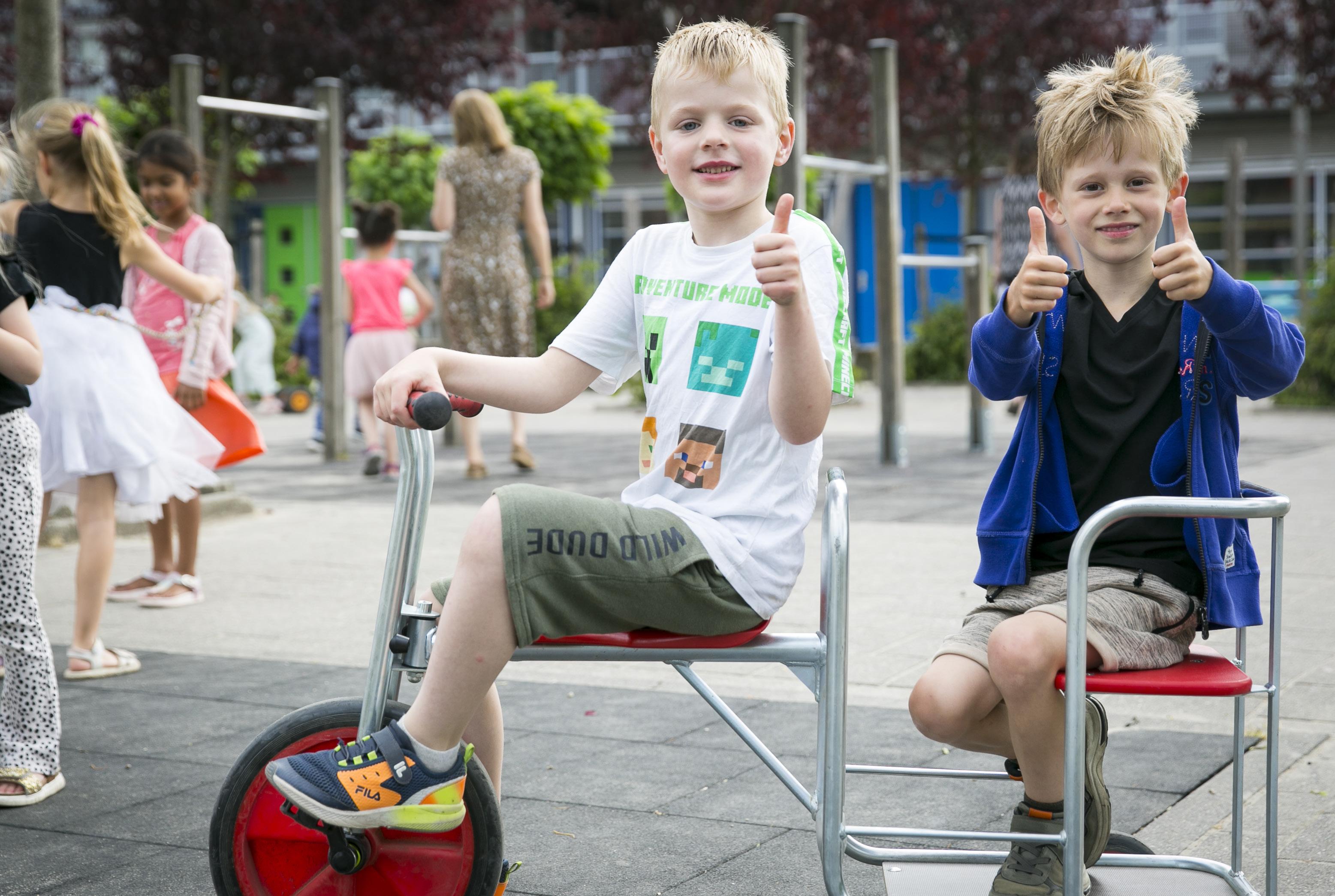 Twee blije jongens geven een duim omhoog terwijl ze op het schoolplein van De Fontein Houten spelen. Twee blije jongens geven een duim omhoog terwijl ze op het schoolplein van De Fontein Houten spelen.