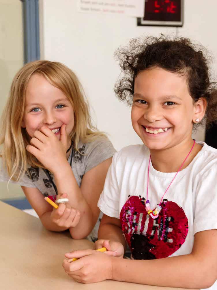 Twee blije kinderen aan een tafel op de Jan Ligthartschool in Arnhem. Twee blije kinderen aan een tafel op de Jan Ligthartschool in Arnhem.