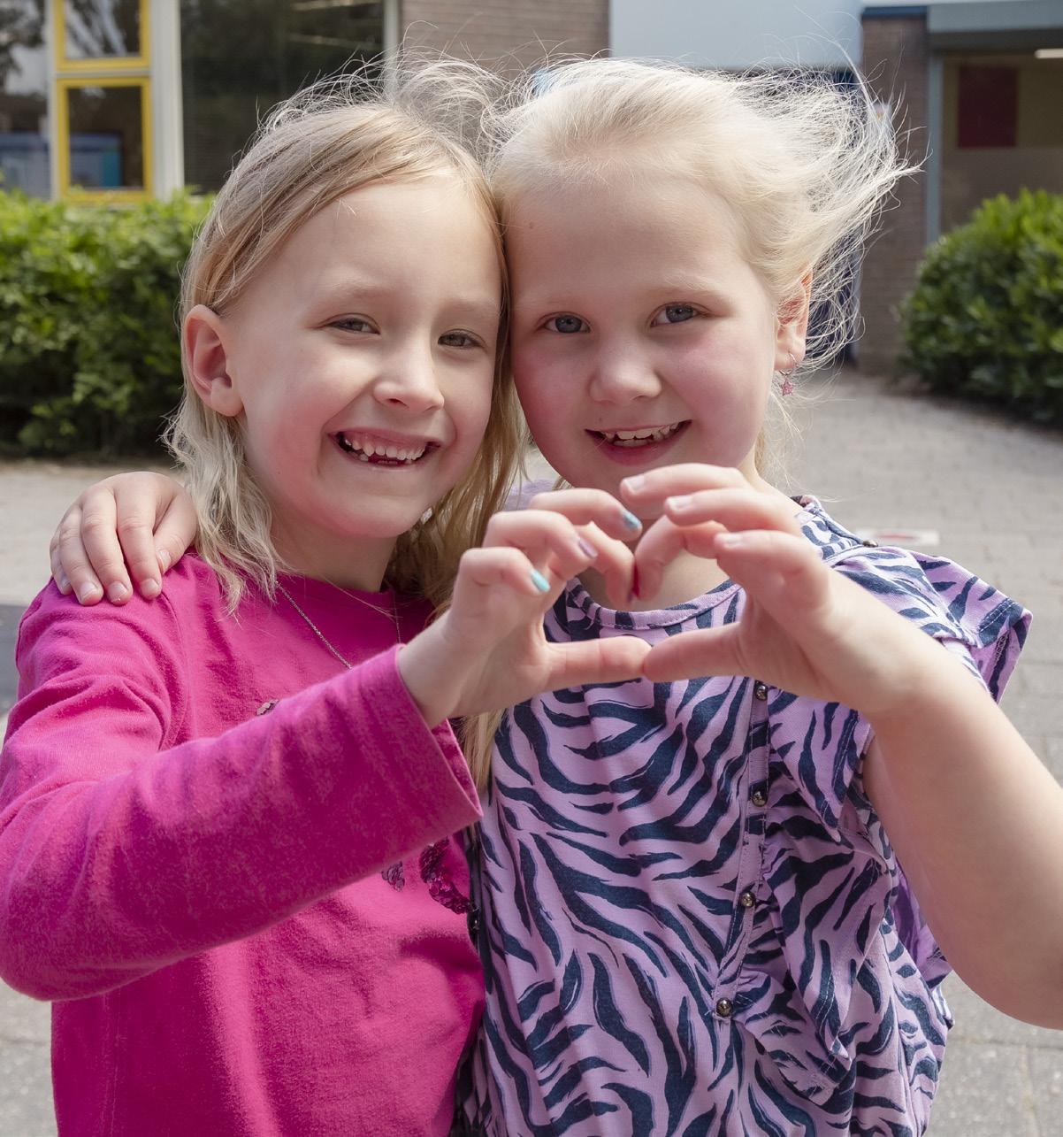 Twee blije kinderen maken een hartvorm met hun handen op het schoolplein van Beatrixschool, locatie Zuilenstein in Nieuwegein. Twee blije kinderen maken een hartvorm met hun handen op het schoolplein van Beatrixschool, locatie Zuilenstein in Nieuwegein.
