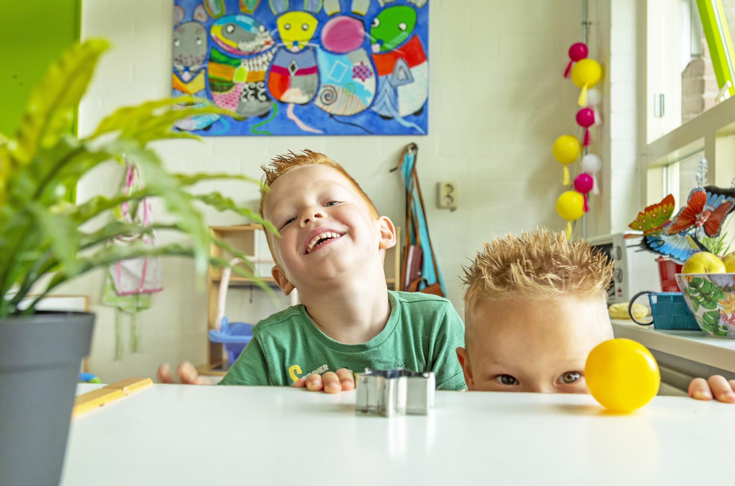 Twee blije kinderen met vrolijke kapsels spelend in de klas van basisschool De Brug in IJsselstein.