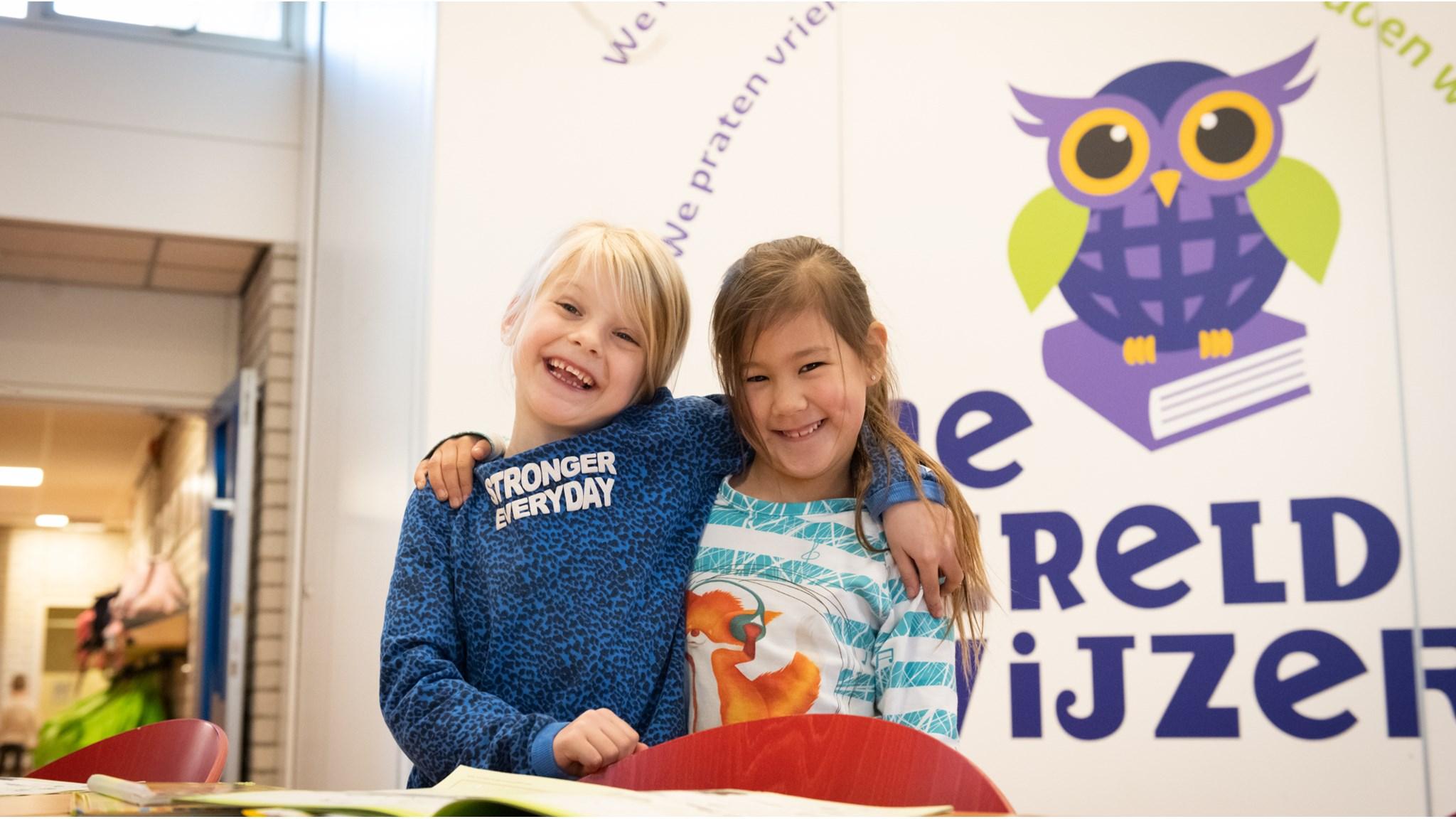 Twee blije kinderen poseren samen in Basisschool De Wereldwijzer in Leiden. Twee blije kinderen poseren samen in Basisschool De Wereldwijzer in Leiden.