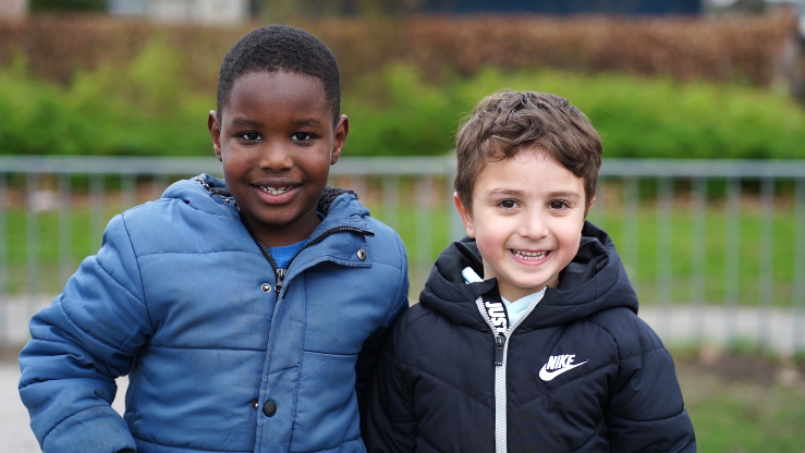 Twee blije kinderen poseren samen op het schoolplein van De Duykeldam in Swifterbant. Twee blije kinderen poseren samen op het schoolplein van De Duykeldam in Swifterbant.