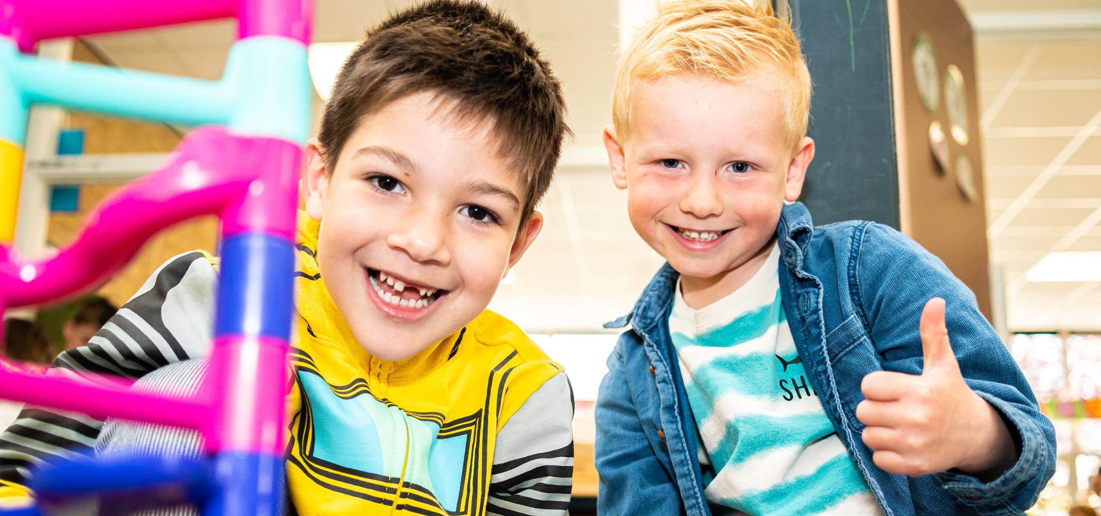 Twee blije kinderen poseren voor de camera op de Fatimaschool in Rotterdam. Twee blije kinderen poseren voor de camera op de Fatimaschool in Rotterdam.