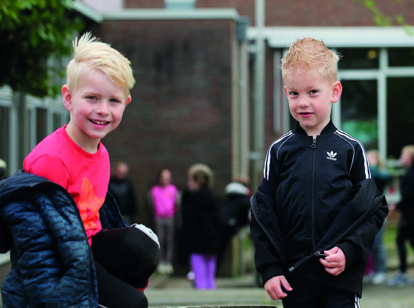 Twee blije kinderen spelen op het schoolplein van Christelijk Kindcentrum De Wiedewereld in Sint Jansklooster. Twee blije kinderen spelen op het schoolplein van Christelijk Kindcentrum De Wiedewereld in Sint Jansklooster.
