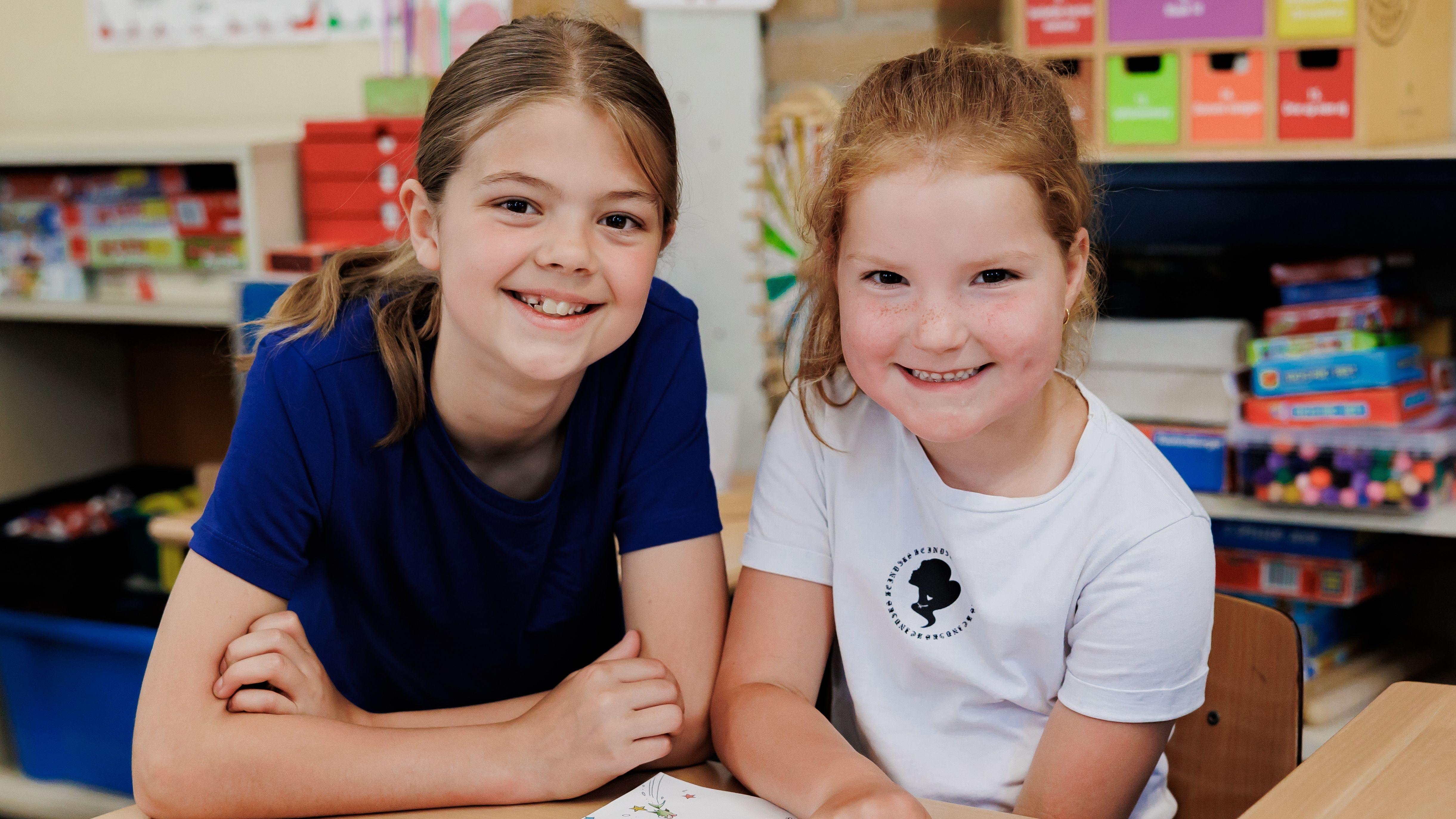 Twee blije meisjes poseren samen in de klas van Basisschool Heilig Hart in Dongen. Twee blije meisjes poseren samen in de klas van Basisschool Heilig Hart in Dongen.