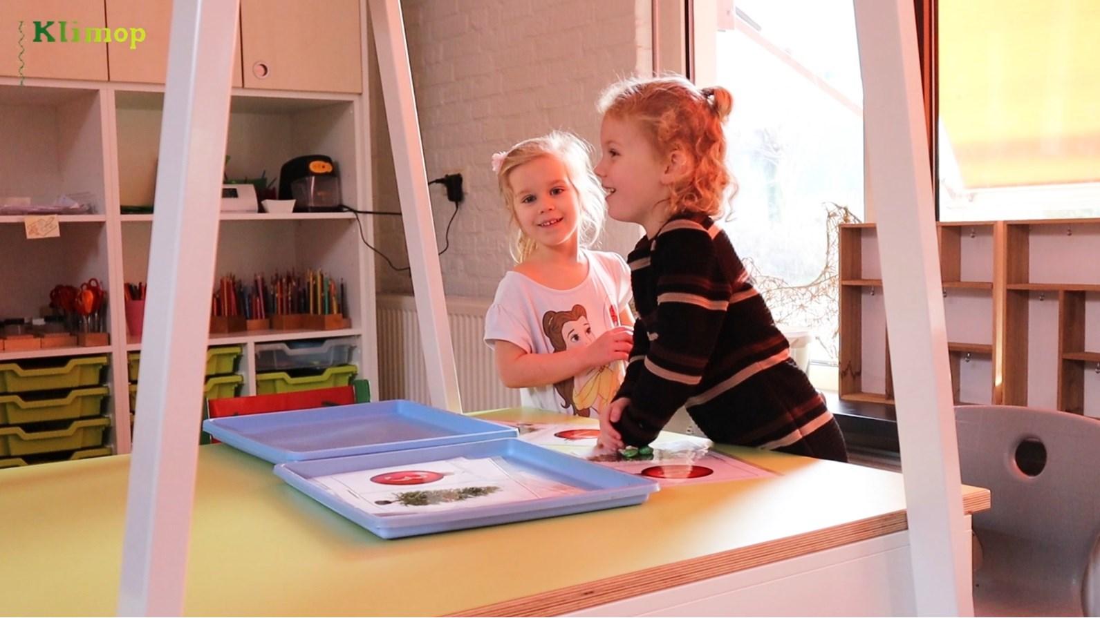 Twee blije meisjes spelen samen in een klaslokaal van Basisschool Klimop in Rijkevoort. Twee blije meisjes spelen samen in een klaslokaal van Basisschool Klimop in Rijkevoort.
