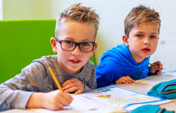 Twee jonge leerlingen van Paulus in Enschede zijn aan het tekenen en leren aan een tafel. Twee jonge leerlingen van Paulus in Enschede zijn aan het tekenen en leren aan een tafel.