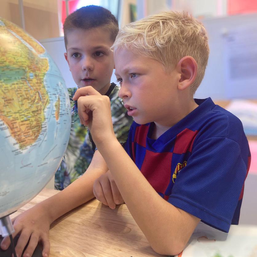 Twee jongens van OBS Het Anker in Wijk bij Duurstede onderzoeken een wereldbol.