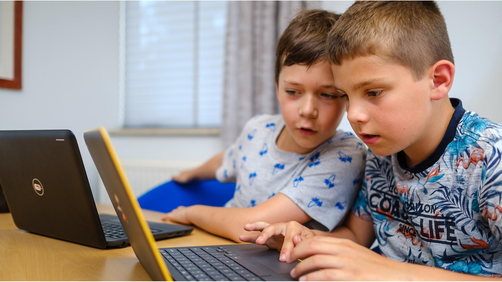 Twee jongens werken samen aan laptops tijdens een les op PCBO Prinses Juliana in Lieren. Twee jongens werken samen aan laptops tijdens een les op PCBO Prinses Juliana in Lieren.