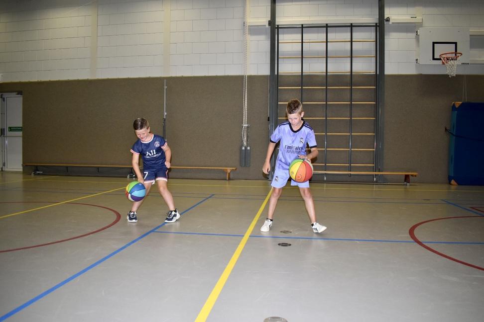 Twee kinderen dribbelen basketballen in de gymzaal van IKC Franciscus in Babberich. Twee kinderen dribbelen basketballen in de gymzaal van IKC Franciscus in Babberich.