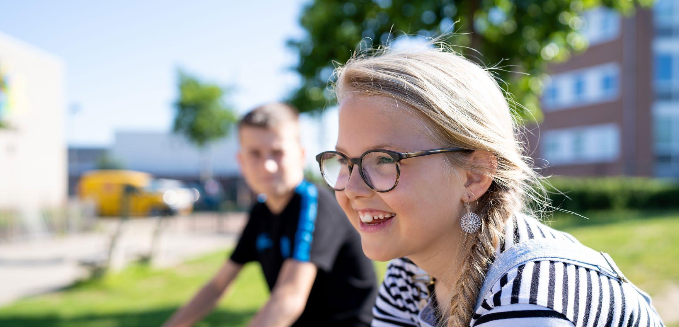 Twee kinderen genieten op het schoolplein van de Hubertusschool in Herten. Twee kinderen genieten op het schoolplein van de Hubertusschool in Herten.
