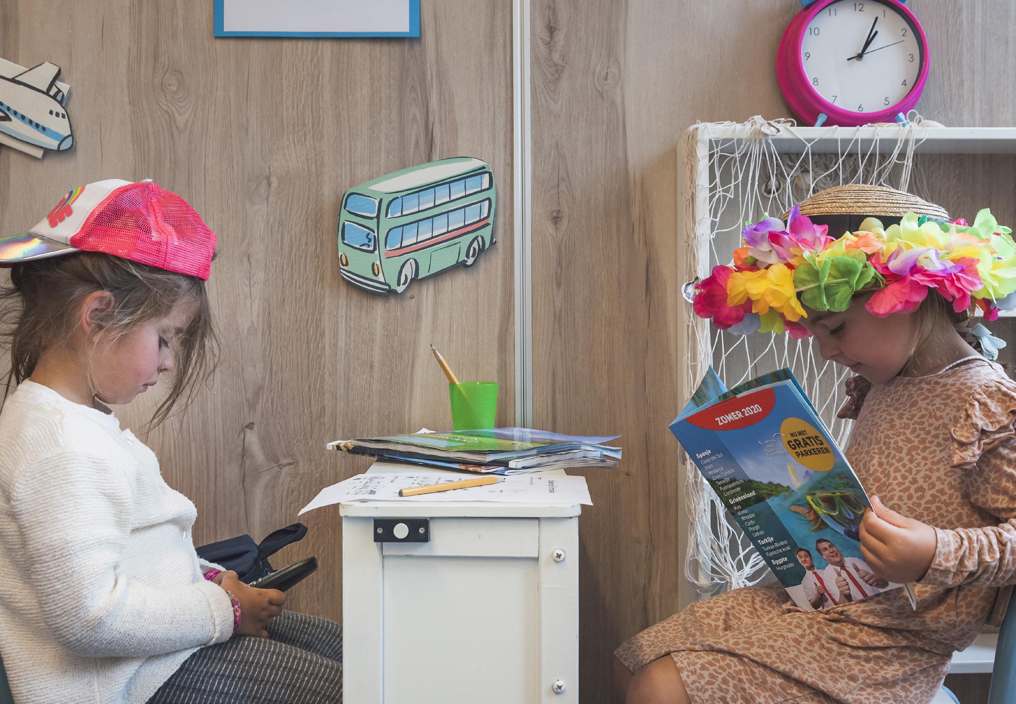 Twee kinderen in de klas van Openbare Basisschool De Hasselbraam in Haaren, één kijkt op haar telefoon en de ander leest een tijdschrift. Twee kinderen in de klas van Openbare Basisschool De Hasselbraam in Haaren, één kijkt op haar telefoon en de ander leest een tijdschrift.