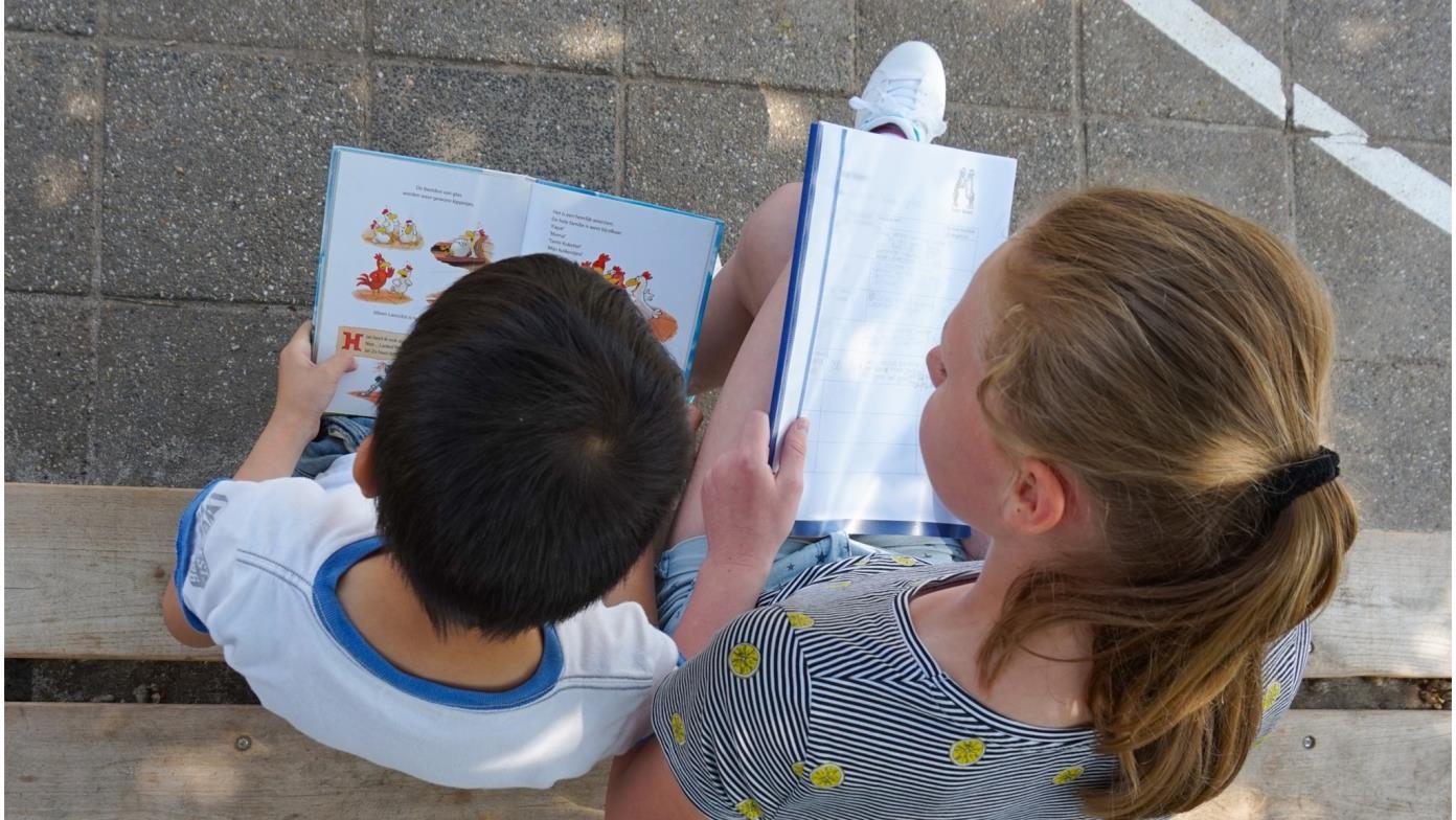 Twee kinderen lezen boeken op het schoolplein van obs de Dubbelster in Amersfoort. Twee kinderen lezen boeken op het schoolplein van obs de Dubbelster in Amersfoort.