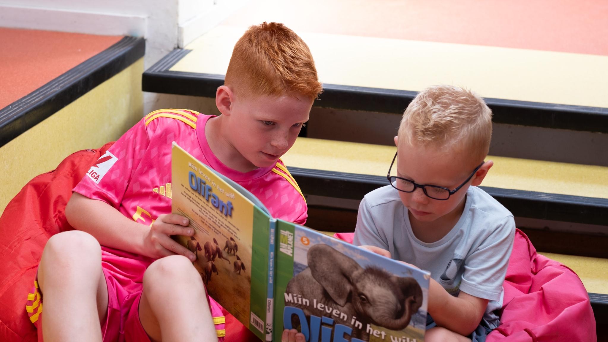 Twee kinderen lezen samen boeken op de trap van Basisschool Bonifatius in Enschede. Twee kinderen lezen samen boeken op de trap van Basisschool Bonifatius in Enschede.