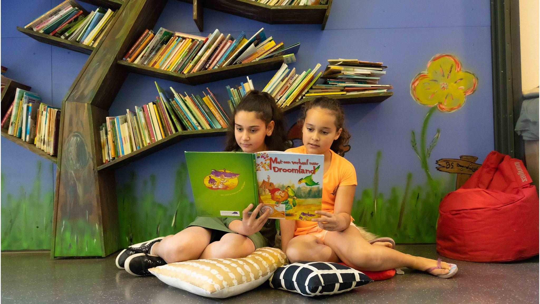 Twee kinderen lezen samen boeken op een kleurrijke leesplek in Basisschool Baardwijk in Waalwijk. Twee kinderen lezen samen boeken op een kleurrijke leesplek in Basisschool Baardwijk in Waalwijk.