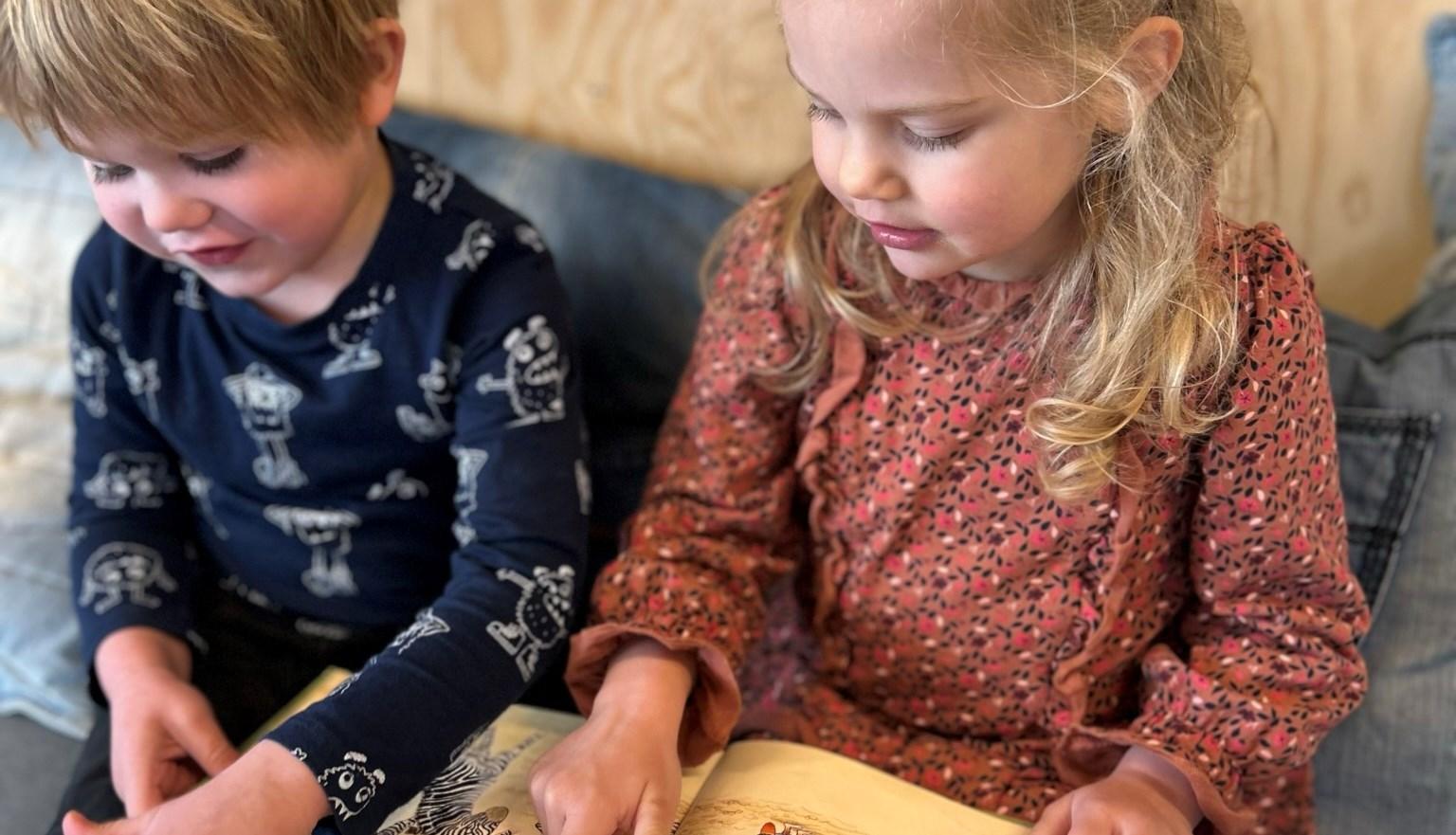 Twee kinderen lezen samen een boek op de bank bij school Opmaat in Nieuw-Vennep.