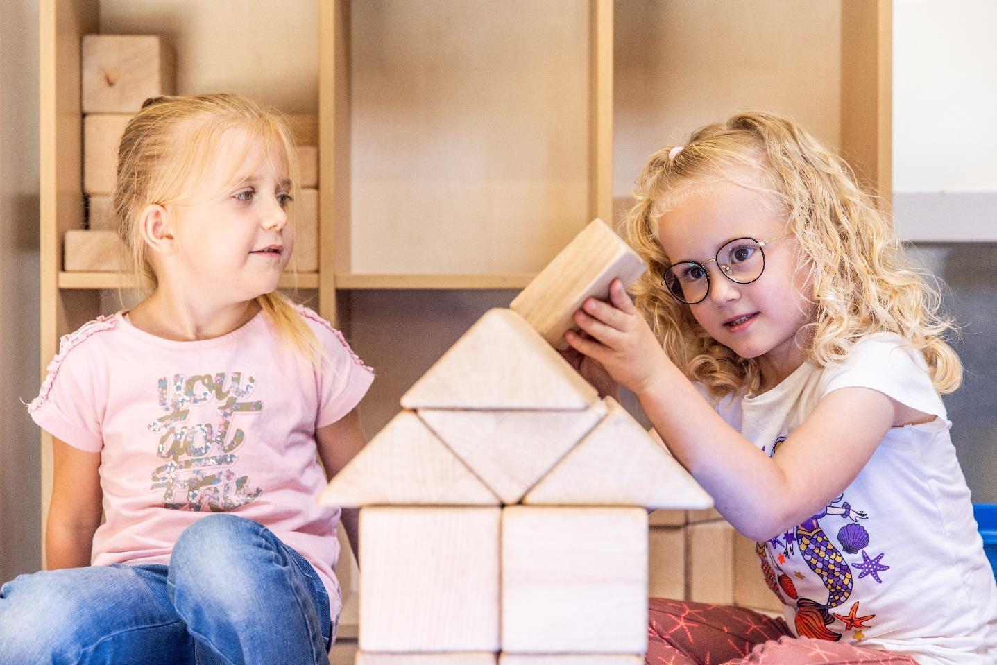 Twee kinderen spelen met houten blokken in de klas van de Prins Mauritsschool in De Lier. Twee kinderen spelen met houten blokken in de klas van de Prins Mauritsschool in De Lier.