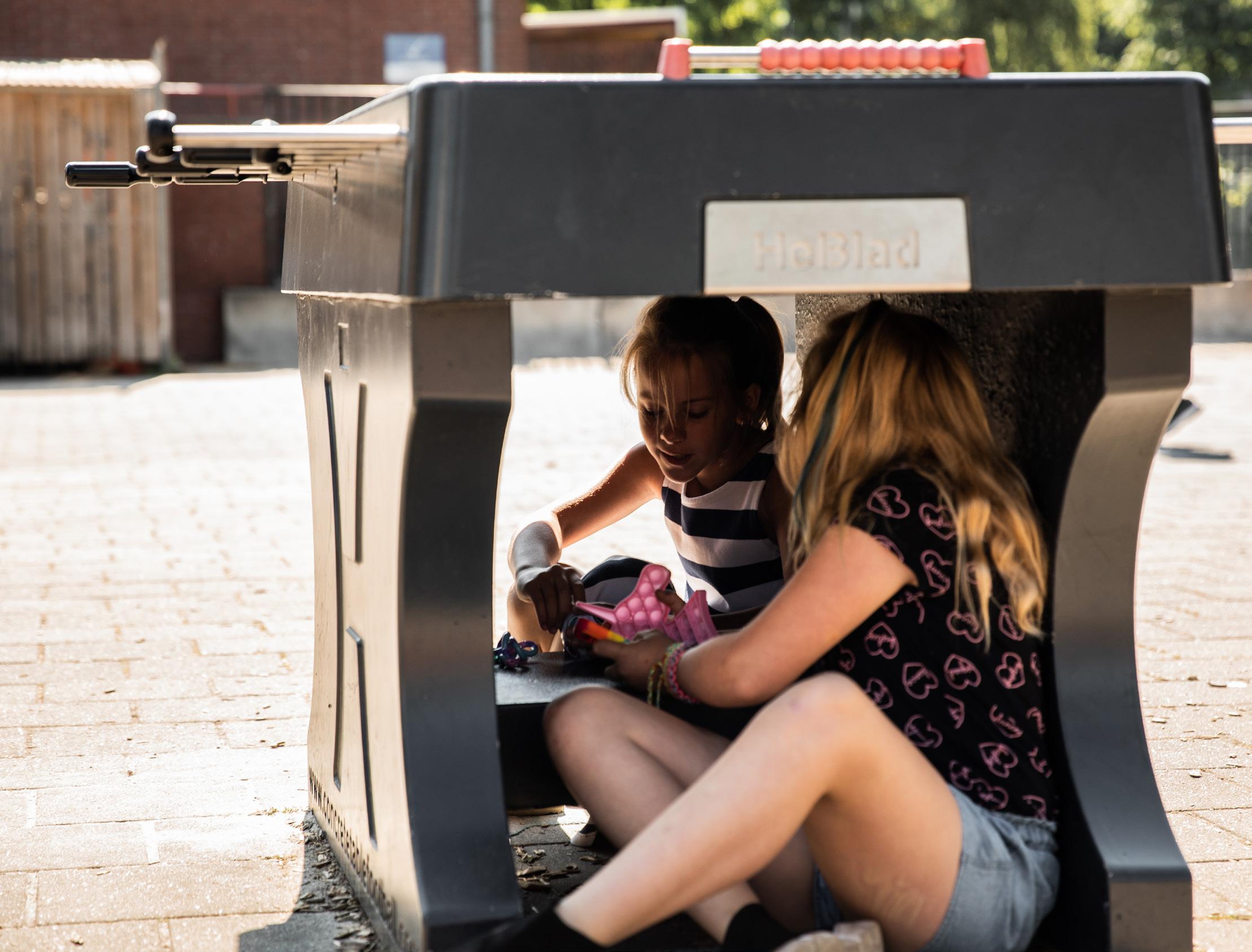 Twee kinderen spelen samen onder een schoolplein tafel op de Paasbergschool in Ede.