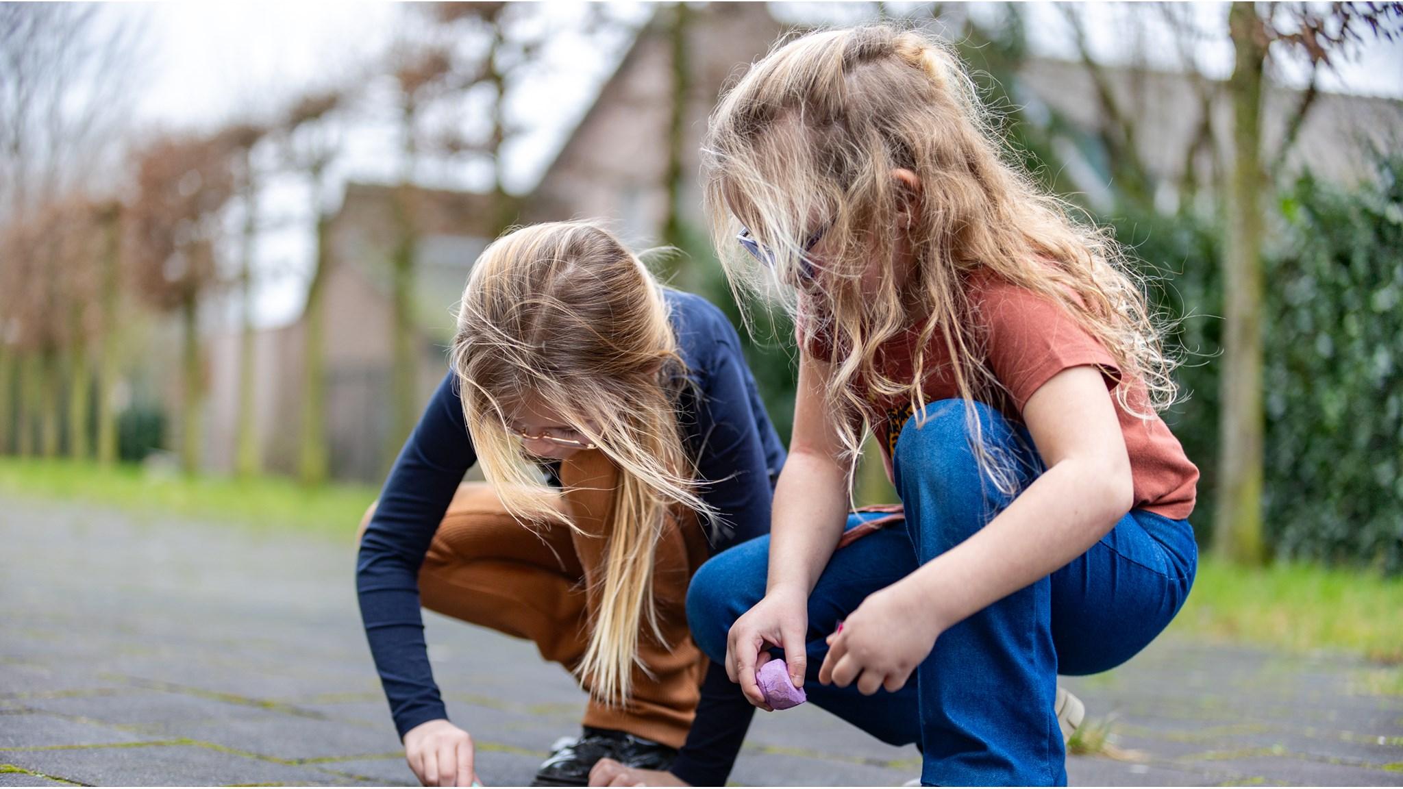 Twee kinderen van Basisschool 't Maxend in Nistelrode spelen met krijt op het schoolplein. Twee kinderen van Basisschool 't Maxend in Nistelrode spelen met krijt op het schoolplein.