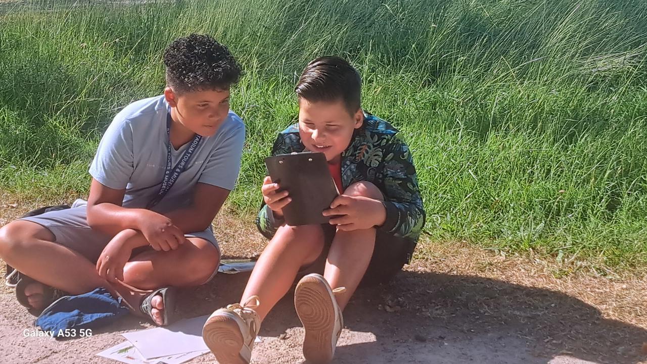 Twee kinderen van BS Het Klinket in Arnhem kijken samen naar een tablet op het schoolplein. Twee kinderen van BS Het Klinket in Arnhem kijken samen naar een tablet op het schoolplein.