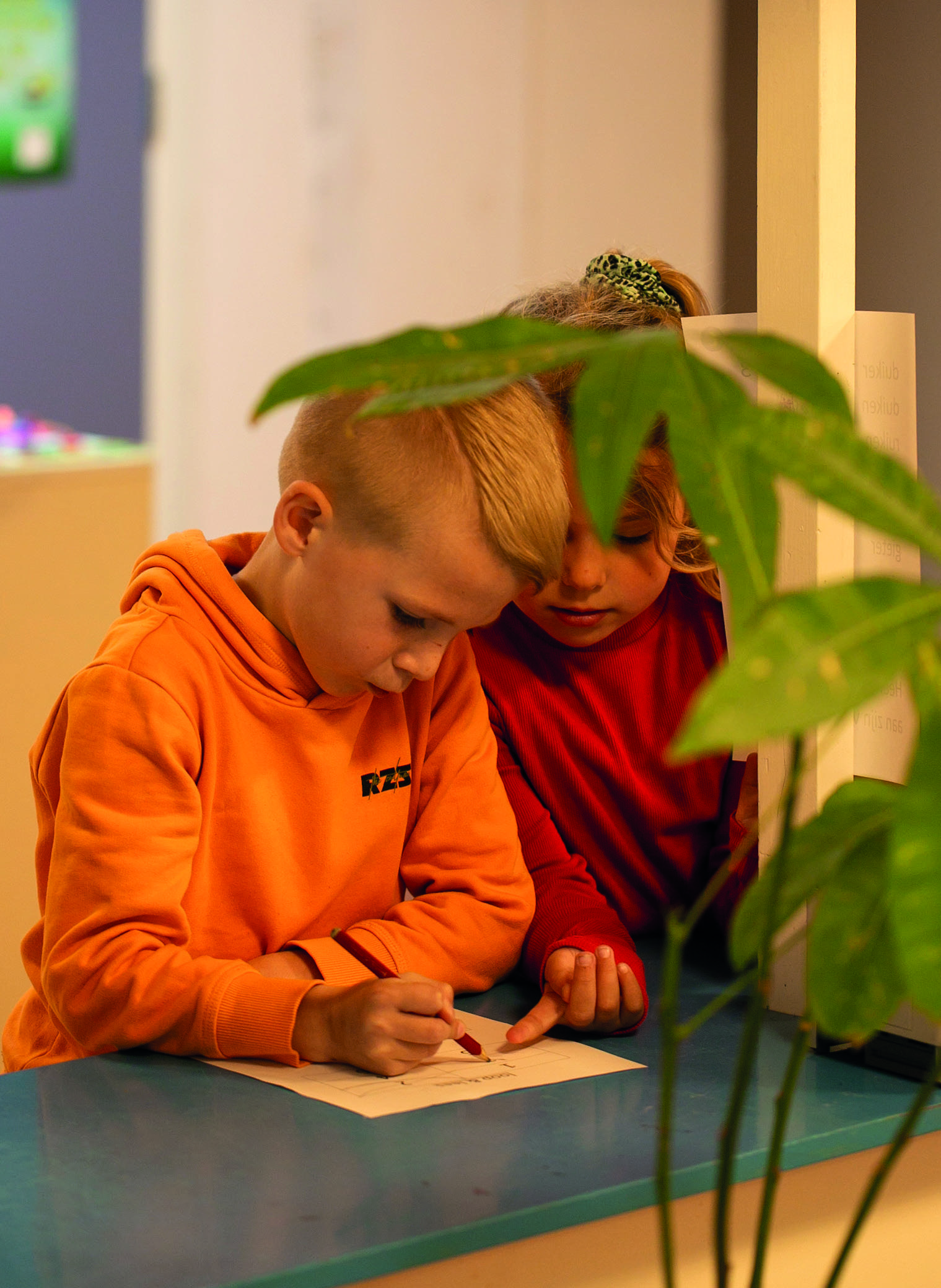 Twee kinderen van Christelijk Kindcentrum Ichthus in Genemuiden zijn samen bezig met tekenen aan een tafel. Twee kinderen van Christelijk Kindcentrum Ichthus in Genemuiden zijn samen bezig met tekenen aan een tafel.