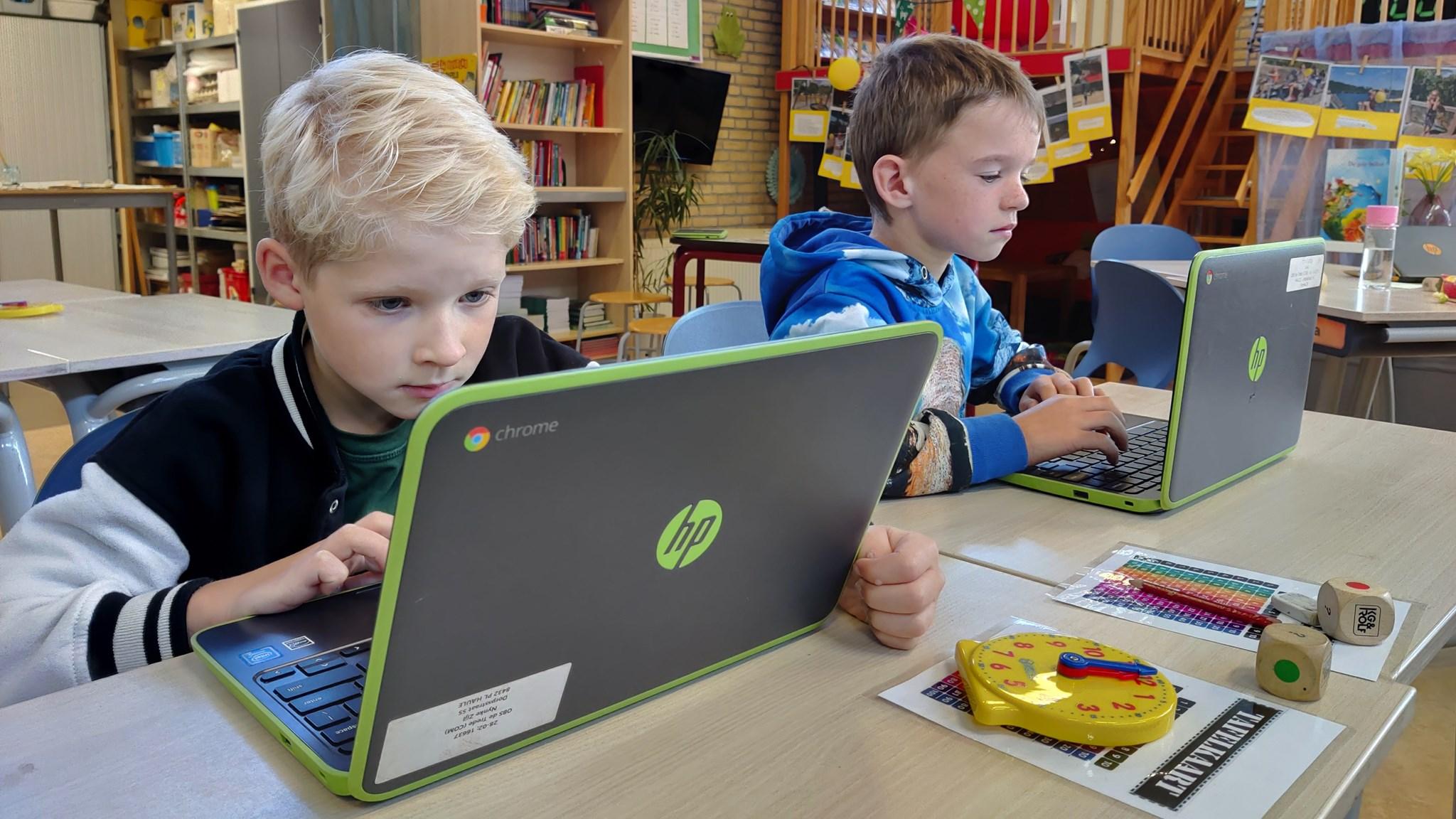 Twee kinderen werken geconcentreerd op laptops in de klas van Openbare Basisschool de Trede in Haule. Twee kinderen werken geconcentreerd op laptops in de klas van Openbare Basisschool de Trede in Haule.