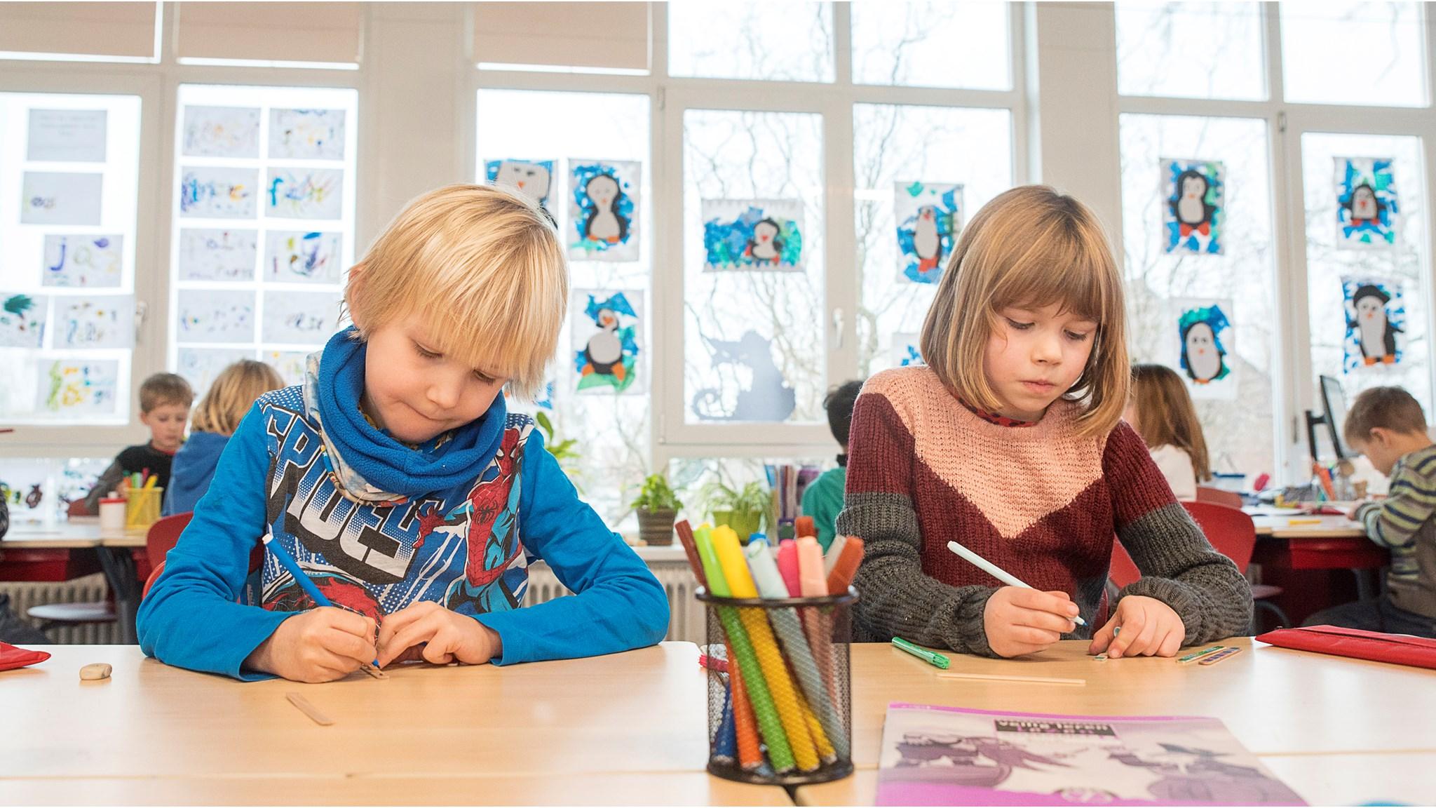Twee kinderen zijn geconcentreerd aan het werk in de klas van OBS Twiske in Amsterdam. Twee kinderen zijn geconcentreerd aan het werk in de klas van OBS Twiske in Amsterdam.