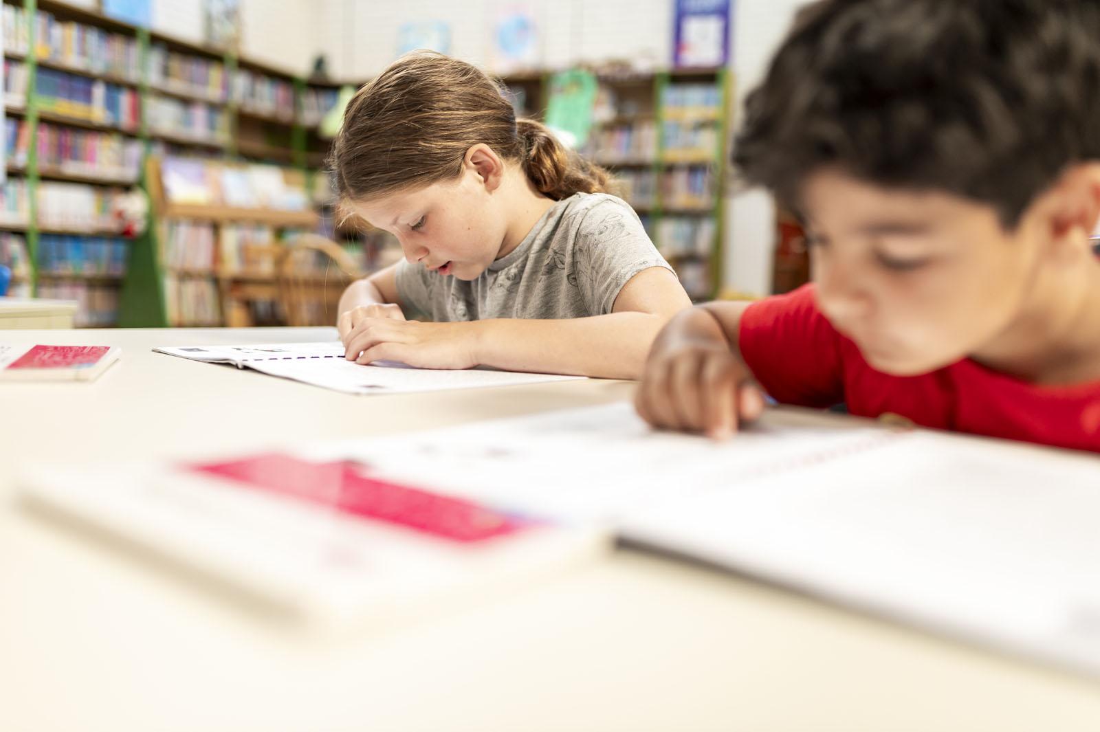 Twee kinderen zijn rustig aan het lezen en schrijven in de bibliotheek van CBS Driestromenland in Lelystad. Twee kinderen zijn rustig aan het lezen en schrijven in de bibliotheek van CBS Driestromenland in Lelystad.