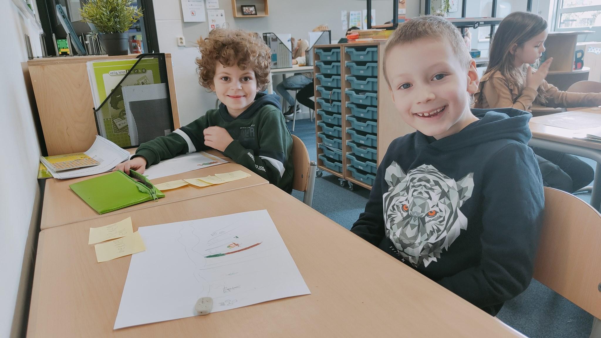 Twee kinderen zitten lachend aan een tafel in de klas van Basisschool De Heihorst in Heibloem. Twee kinderen zitten lachend aan een tafel in de klas van Basisschool De Heihorst in Heibloem.