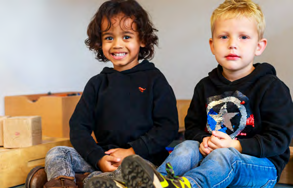 Twee kinderen zitten vrolijk op de vloer in de klas van basisschool Paulus in Enschede. Twee kinderen zitten vrolijk op de vloer in de klas van basisschool Paulus in Enschede.