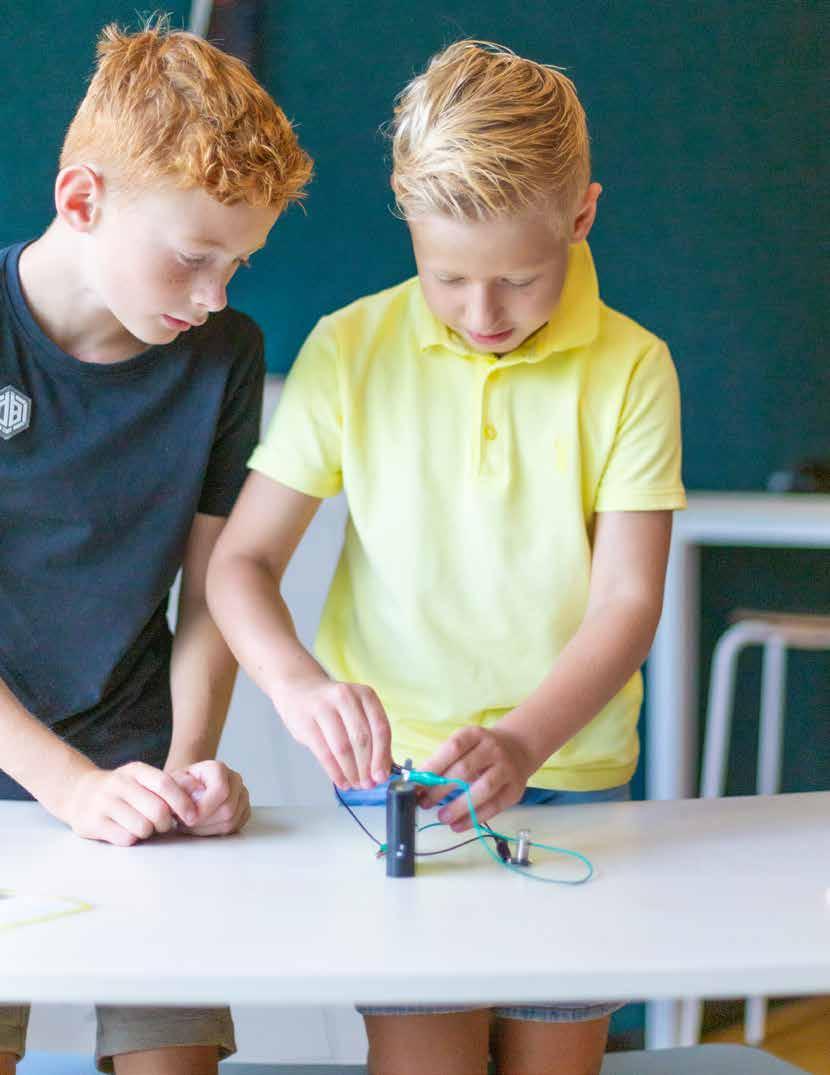 Twee leerlingen op De Triangel in Enschede zijn bezig met een wetenschappelijk experiment aan een tafel. Twee leerlingen op De Triangel in Enschede zijn bezig met een wetenschappelijk experiment aan een tafel.
