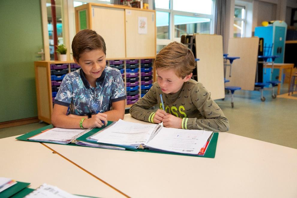 Twee leerlingen van Basisschool De Uilenburcht in Driebergen-Rijsenburg zijn samen aan het werk met hun schoolboeken. Twee leerlingen van Basisschool De Uilenburcht in Driebergen-Rijsenburg zijn samen aan het werk met hun schoolboeken.