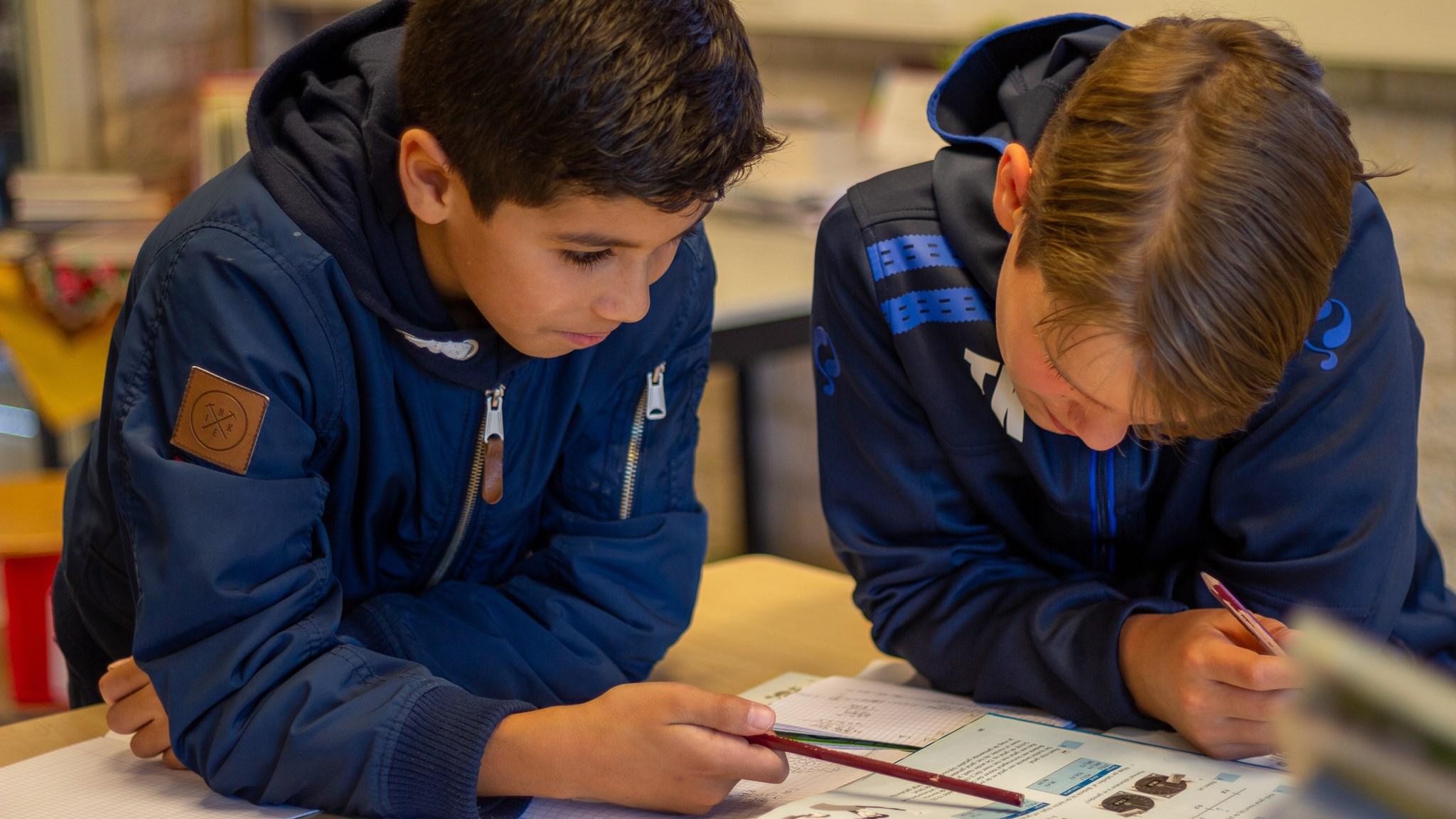 Twee leerlingen van Basisschool Jules Verne in Utrecht zijn geconcentreerd bezig met hun schoolwerk. Twee leerlingen van Basisschool Jules Verne in Utrecht zijn geconcentreerd bezig met hun schoolwerk.