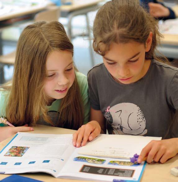 Twee leerlingen van de Lorentzschool in Leiden zitten samen aan een tafel en bestuderen een boek. Twee leerlingen van de Lorentzschool in Leiden zitten samen aan een tafel en bestuderen een boek.