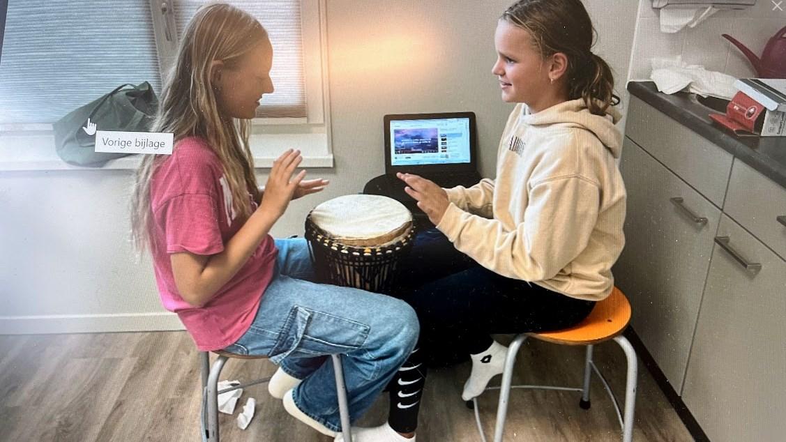 Twee leerlingen van Openbare Basisschool Meester Haye in Beets spelen op een djembé terwijl ze de muziek volgen op een laptop. Twee leerlingen van Openbare Basisschool Meester Haye in Beets spelen op een djembé terwijl ze de muziek volgen op een laptop.