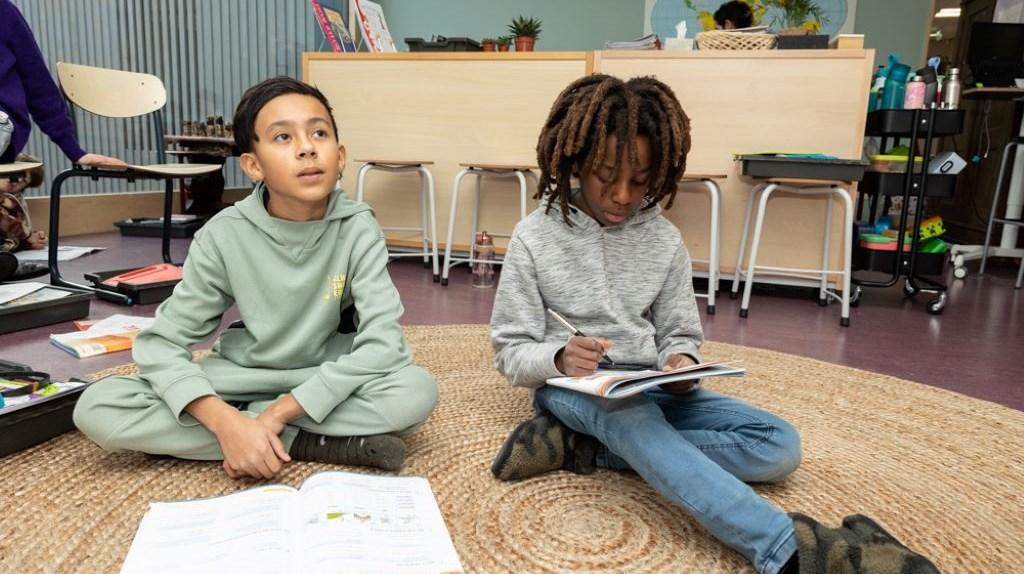 Twee leerlingen van Openbare Jenaplan Basisschool Oldenije in Leeuwarden zijn aan het leren in een klaslokaal.