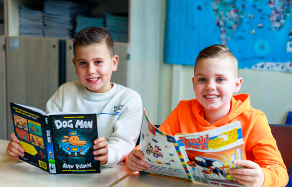 Twee leerlingen van Paulus in Enschede lezen enthousiast boeken in de klas. Twee leerlingen van Paulus in Enschede lezen enthousiast boeken in de klas.