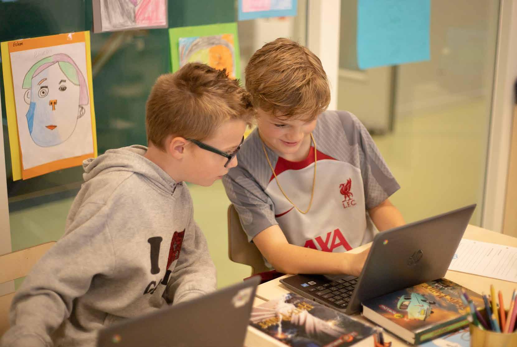 Twee leerlingen werken samen aan een laptop in het klaslokaal van school 'Het Avontuur' in Hoef en Haag.