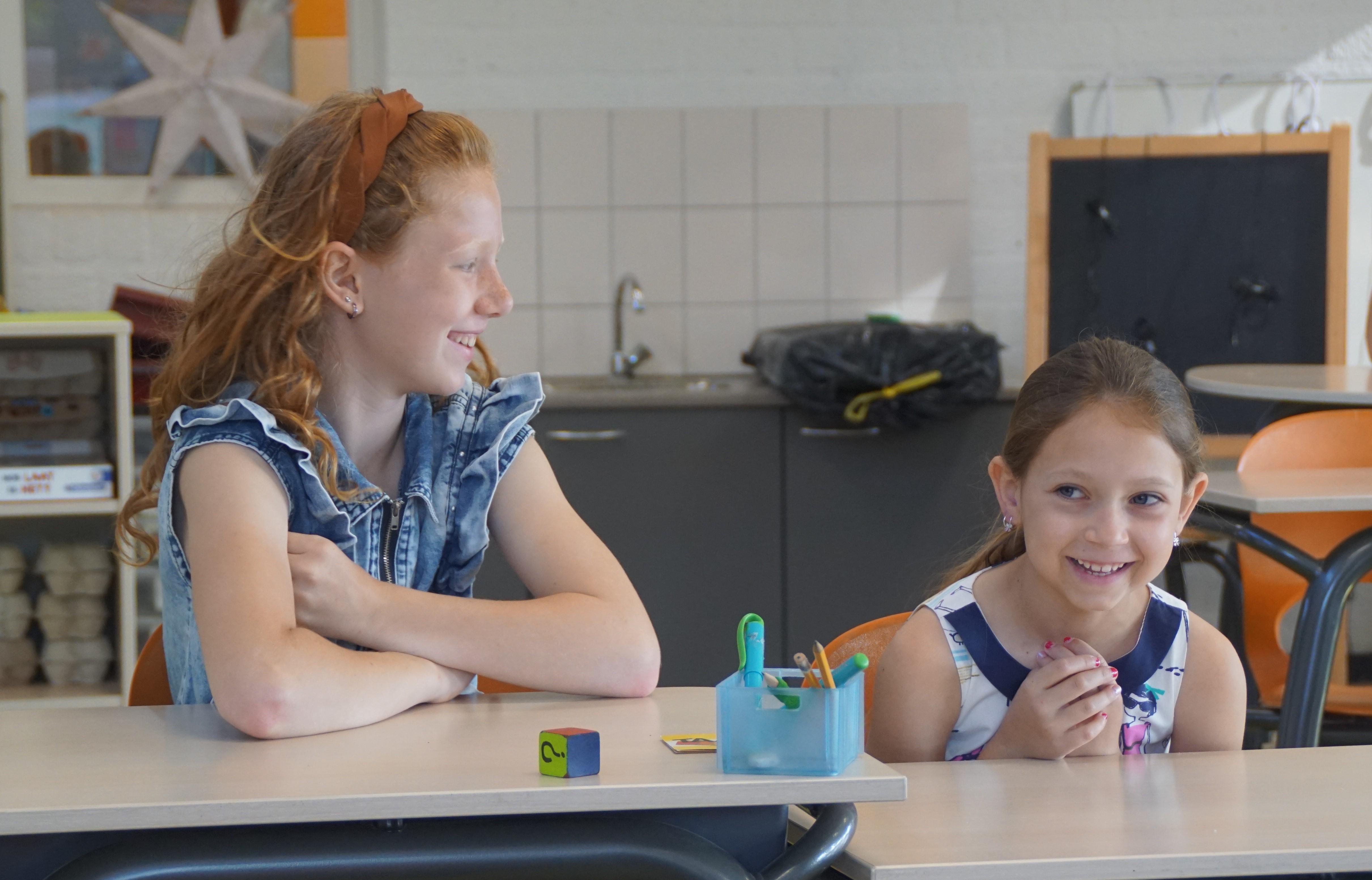 Twee meisjes lachen en genieten van hun tijd samen in de klas van RK Basisschool St Antonius in Maren-Kessel. Twee meisjes lachen en genieten van hun tijd samen in de klas van RK Basisschool St Antonius in Maren-Kessel.