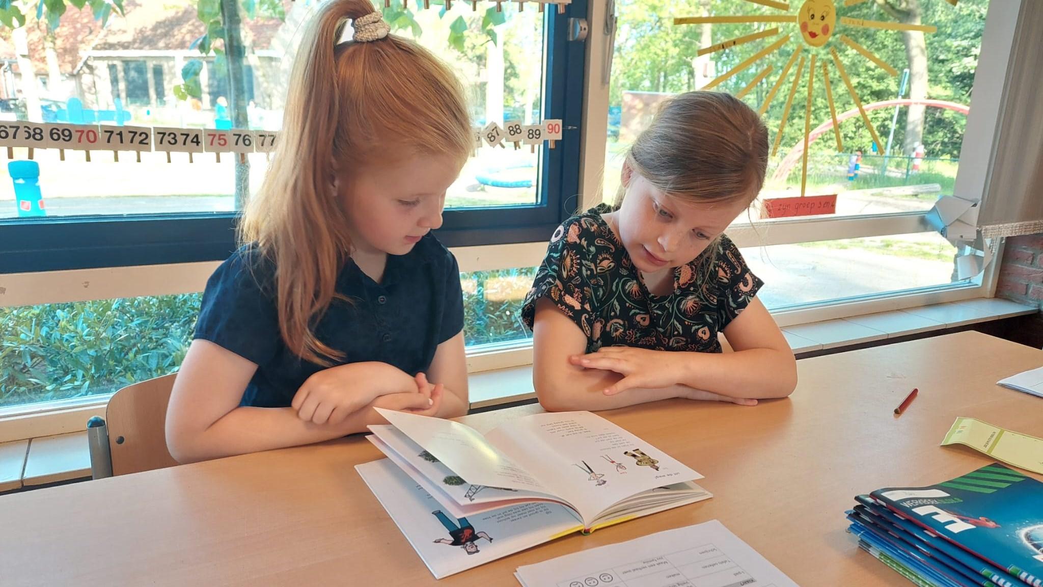 Twee meisjes lezen samen een boek in de klas van Basisschool Honesch in Haaksbergen. Twee meisjes lezen samen een boek in de klas van Basisschool Honesch in Haaksbergen.
