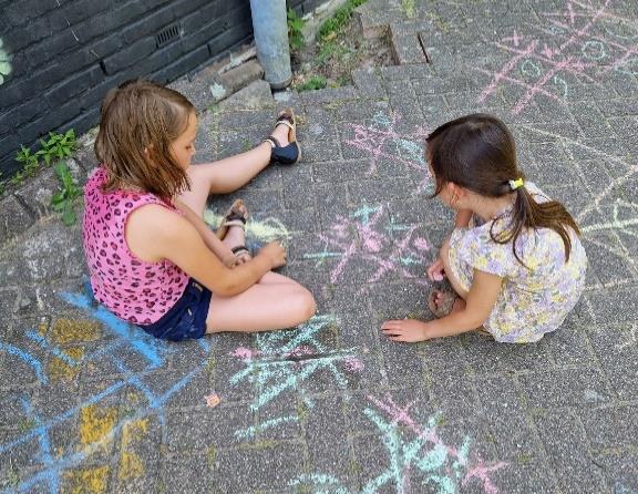 Twee meisjes spelen met krijt op het schoolplein van Christelijk IKC Het Kristal in Dordrecht. Twee meisjes spelen met krijt op het schoolplein van Christelijk IKC Het Kristal in Dordrecht.