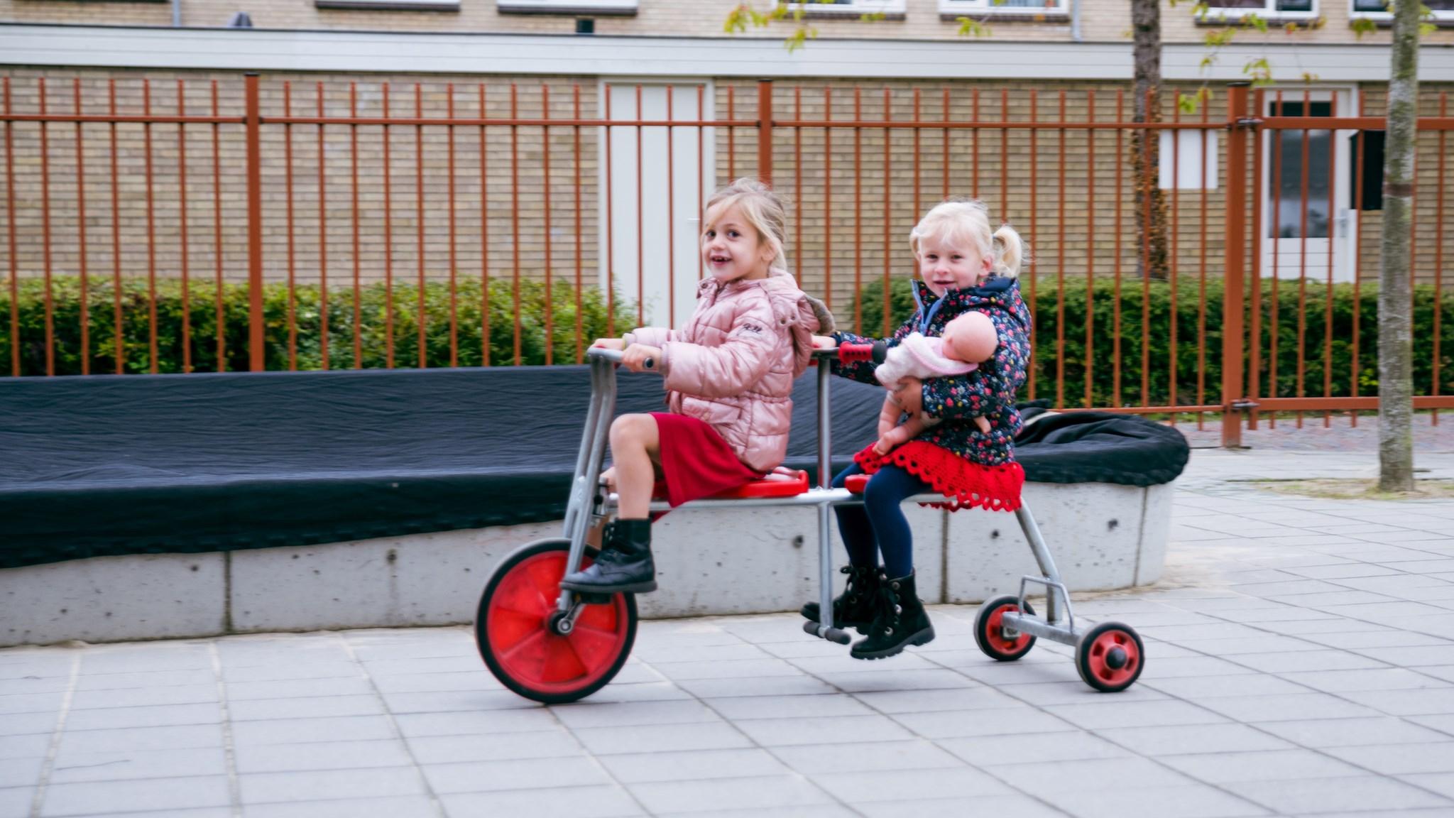 Twee meisjes spelen op een fiets in het schoolplein van Basisschool met de Bijbel Het Kompas in Montfoort. Twee meisjes spelen op een fiets in het schoolplein van Basisschool met de Bijbel Het Kompas in Montfoort.