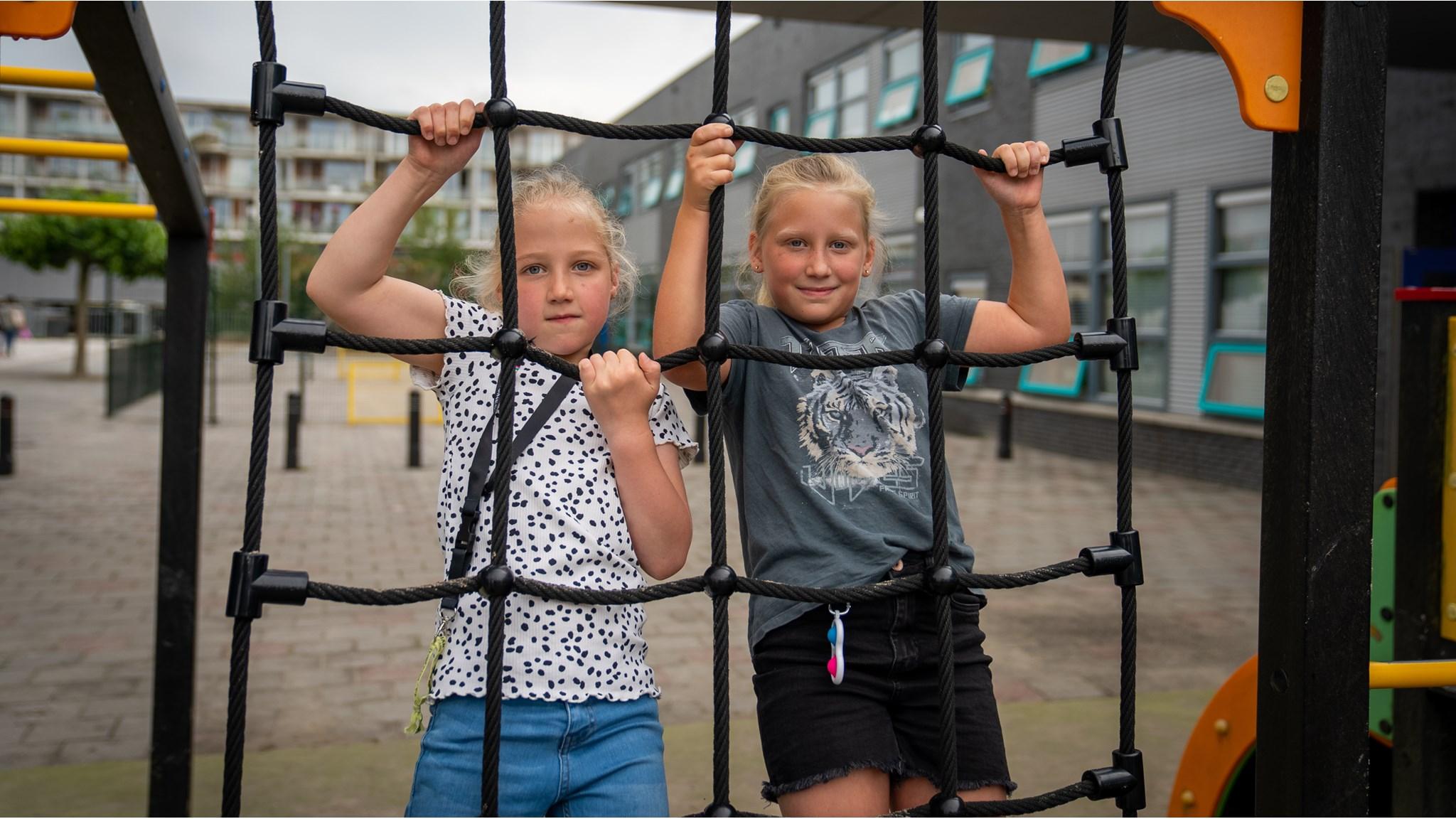Twee meisjes spelen op het schoolplein van de Oecumenische Daltonschool De Windwijzer in Almere. Twee meisjes spelen op het schoolplein van de Oecumenische Daltonschool De Windwijzer in Almere.