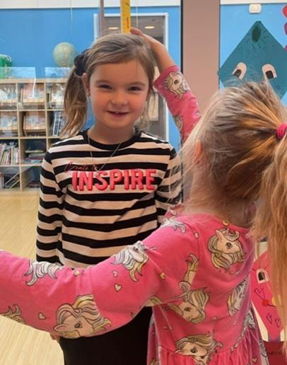 Twee meisjes spelen samen in OBS De Driesprong in Nieuwlande, waarbij één meisje een shirt met 'INSPIRE' draagt.