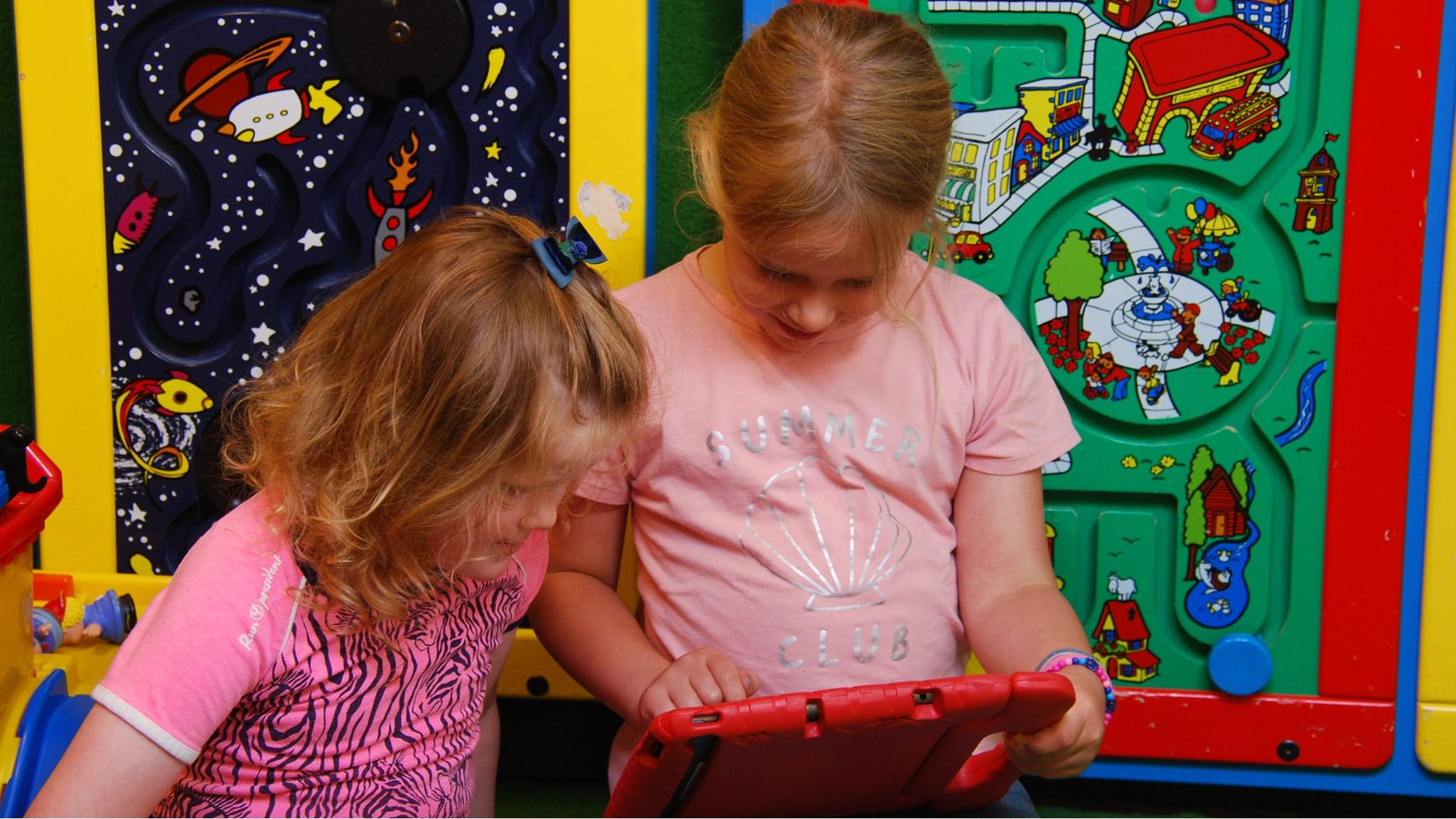 Twee meisjes spelen samen met een tablet op het schoolplein van obs De Dubbelburg in Valkenburg (Zuid-Holland). Twee meisjes spelen samen met een tablet op het schoolplein van obs De Dubbelburg in Valkenburg (Zuid-Holland).