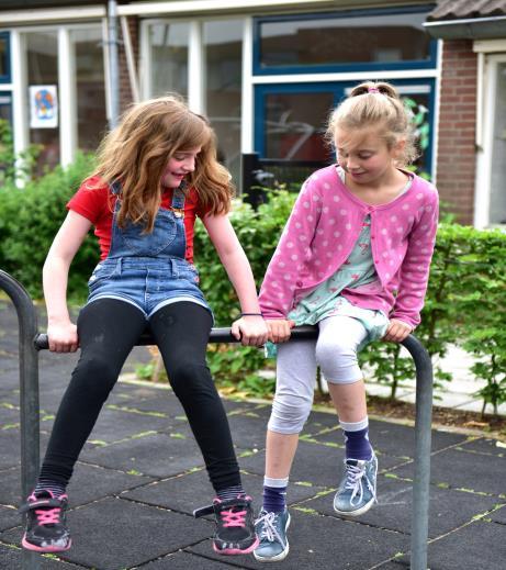 Twee meisjes spelen samen op het schoolplein van De Wereldwijzer in Utrecht. Twee meisjes spelen samen op het schoolplein van De Wereldwijzer in Utrecht.
