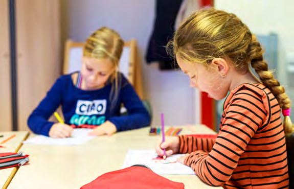 Twee meisjes van basisschool Paulus in Enschede maken huiswerk aan een tafel. Twee meisjes van basisschool Paulus in Enschede maken huiswerk aan een tafel.