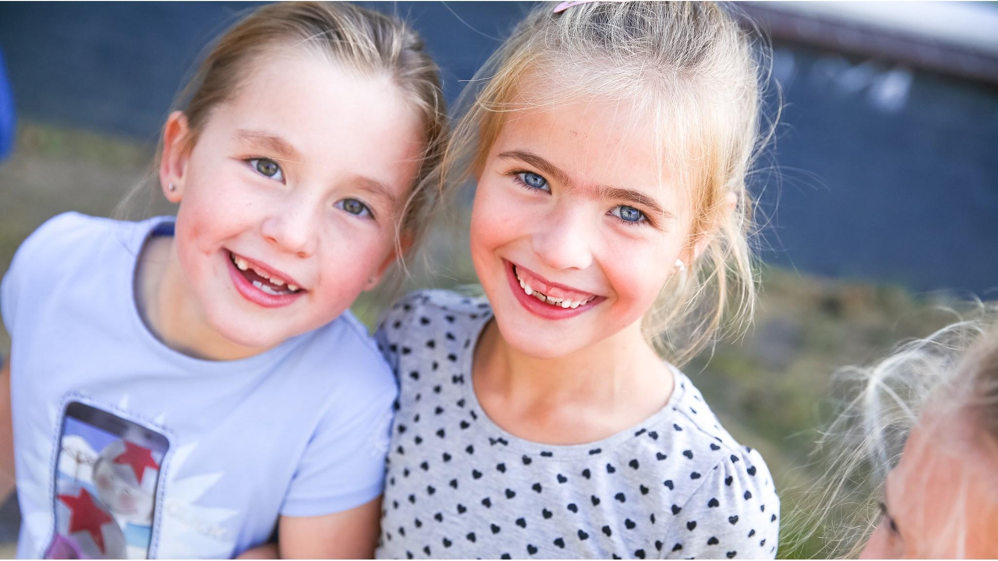 Twee vrolijke meisjes poseren samen op het schoolplein van Basisschool St Joan in Soerendonk. Twee vrolijke meisjes poseren samen op het schoolplein van Basisschool St Joan in Soerendonk.